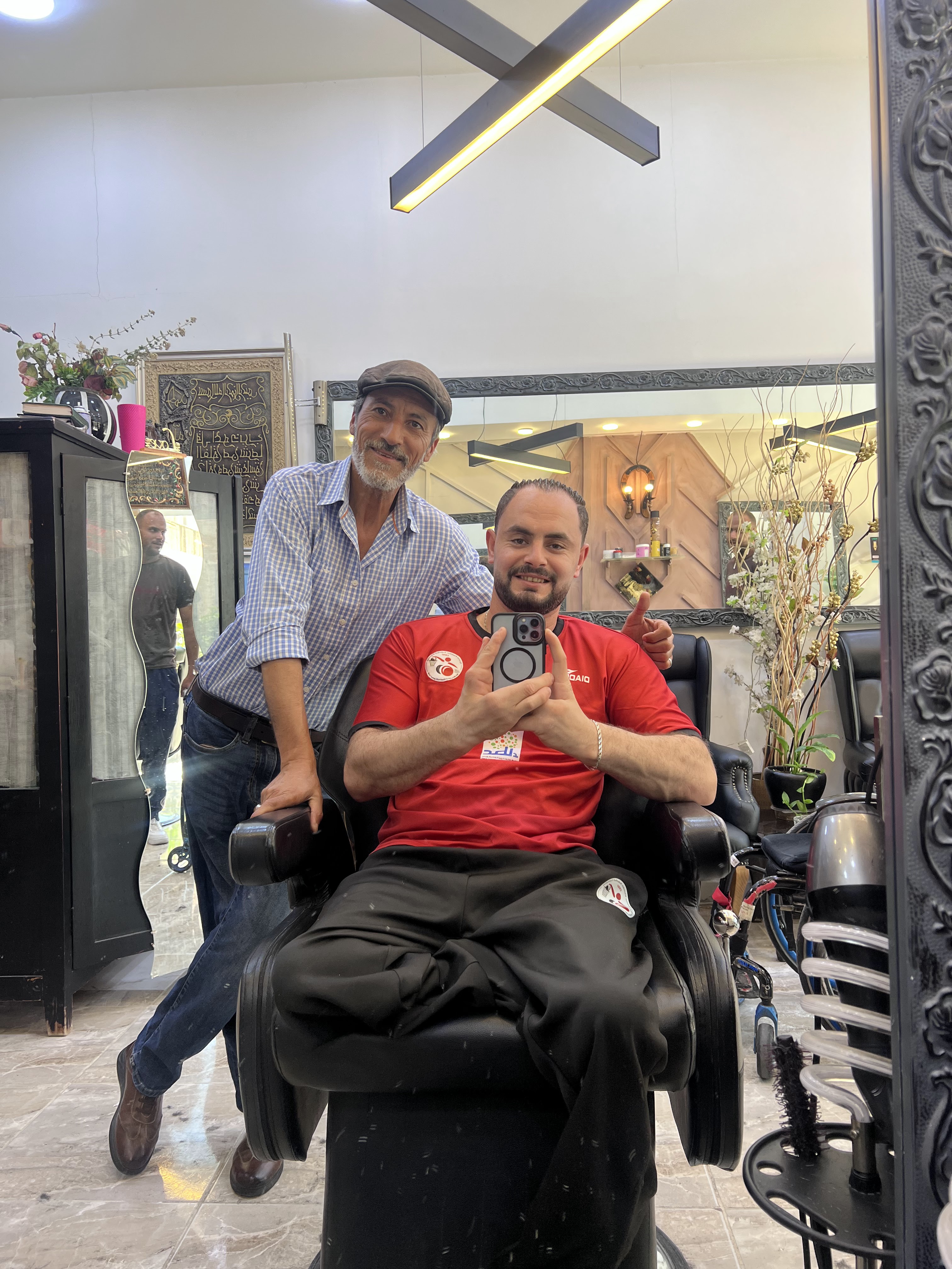 Barber and client posing together in the shop